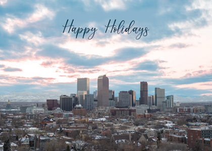 A holiday card of the Skyline of Denver with the Rocky Mountains in the background